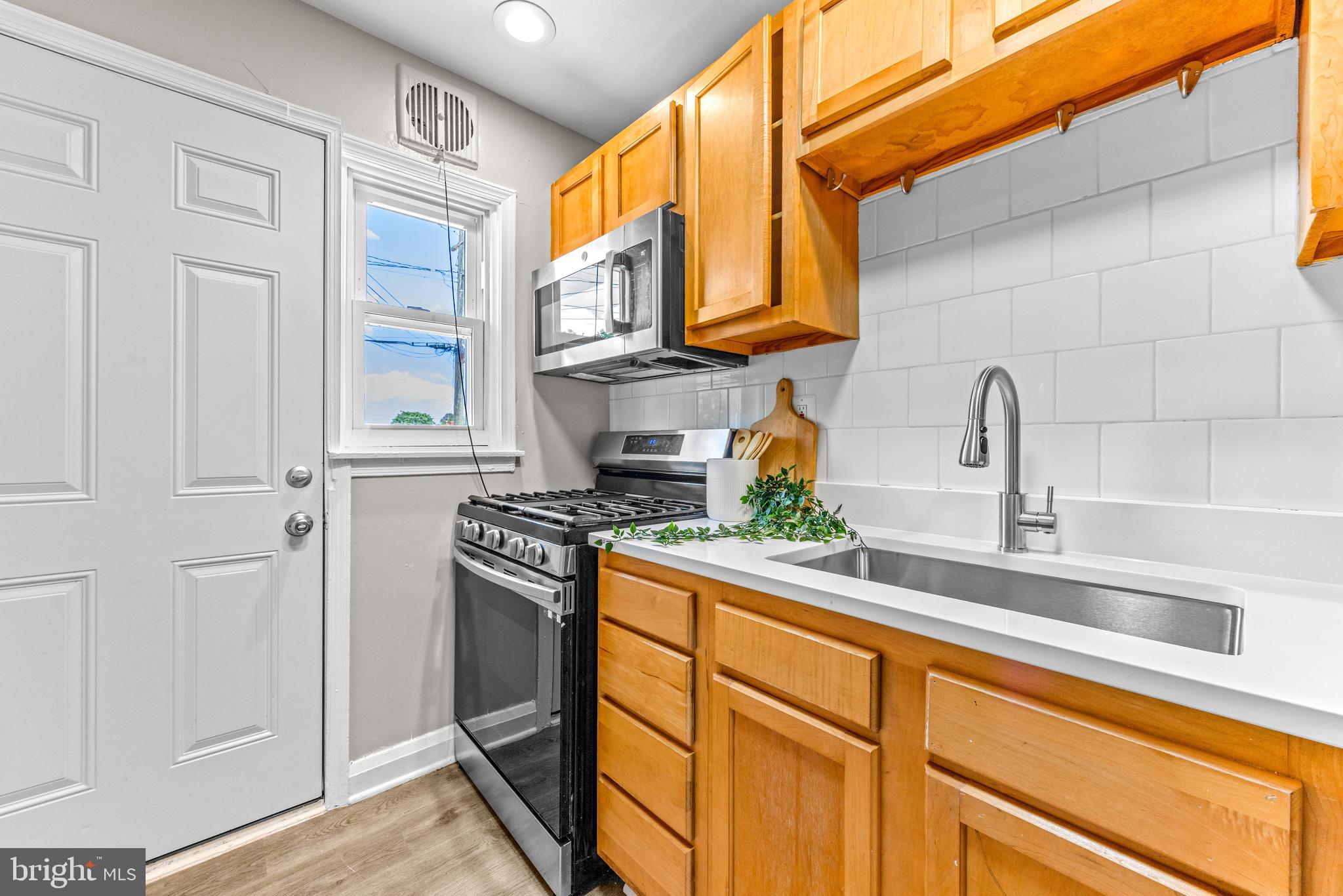 8450 Kavanagh Road Dundalk, MD 21222 - Photo 13 of 32 a kitchen with stainless steel appliances granite countertop a sink stove and cabinets