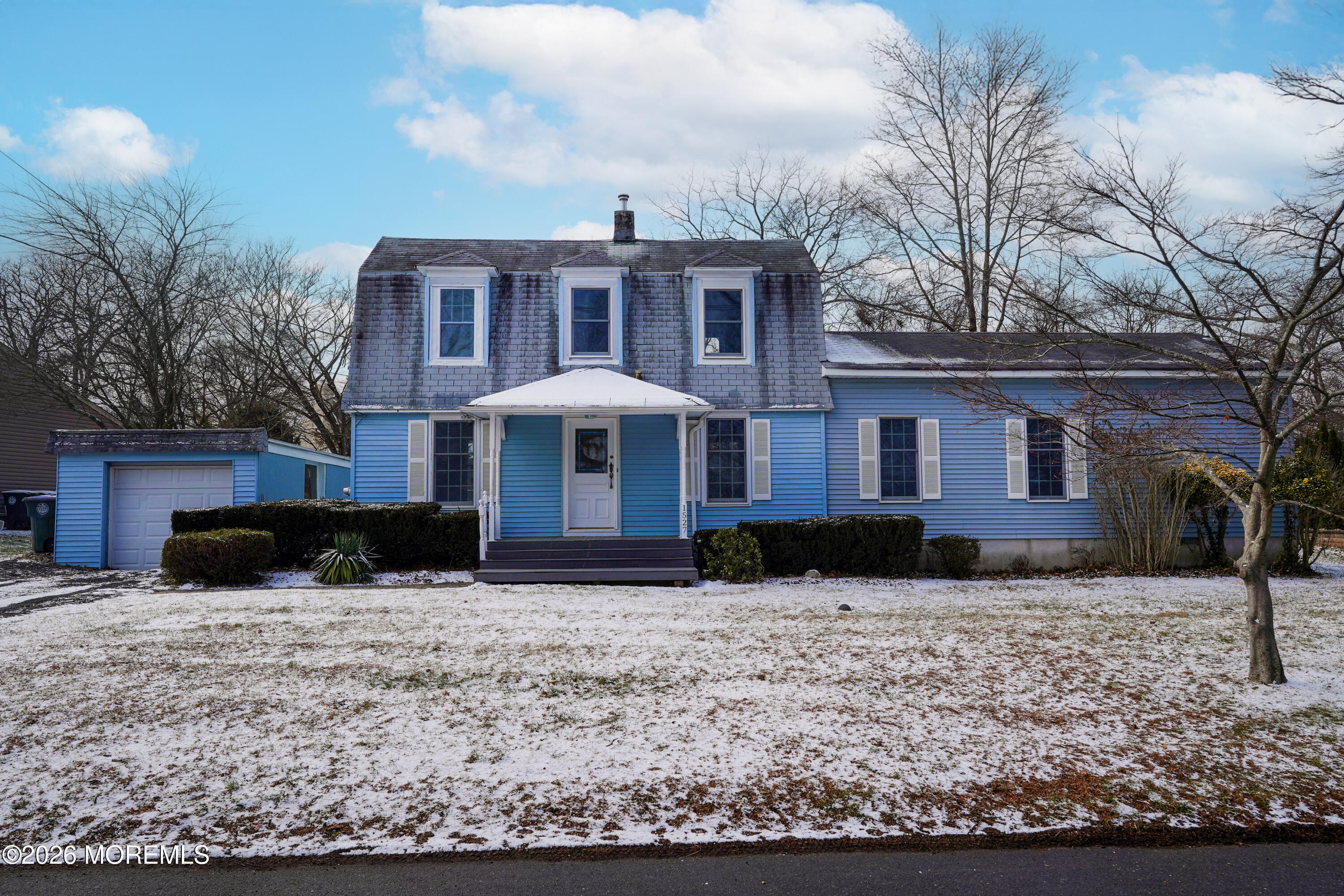 a front view of a house with a yard covered in snow