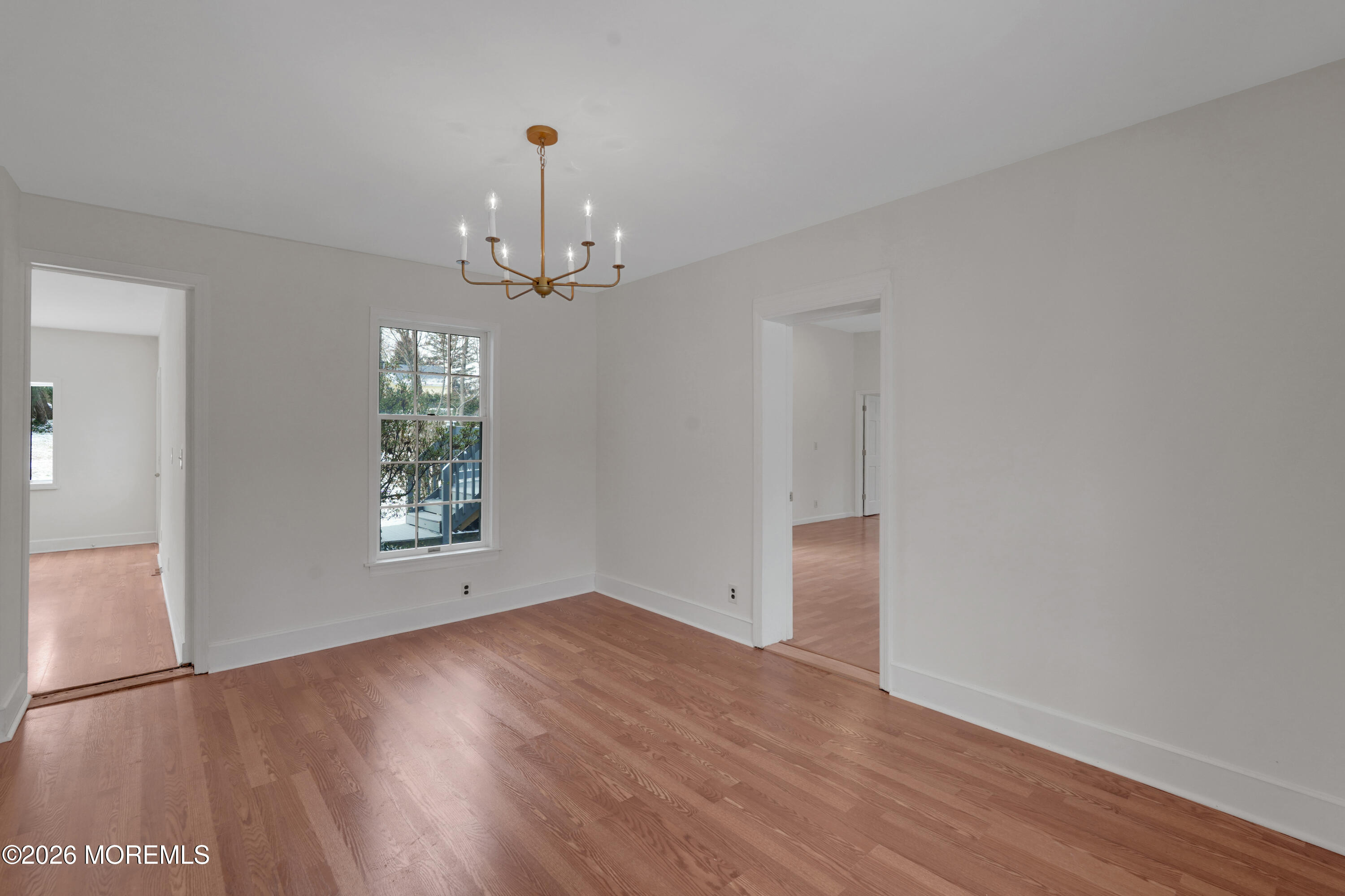 1527 Marconi Road Wall, NJ 07719 - Photo 19 of 25 an empty room with wooden floor chandelier and windows