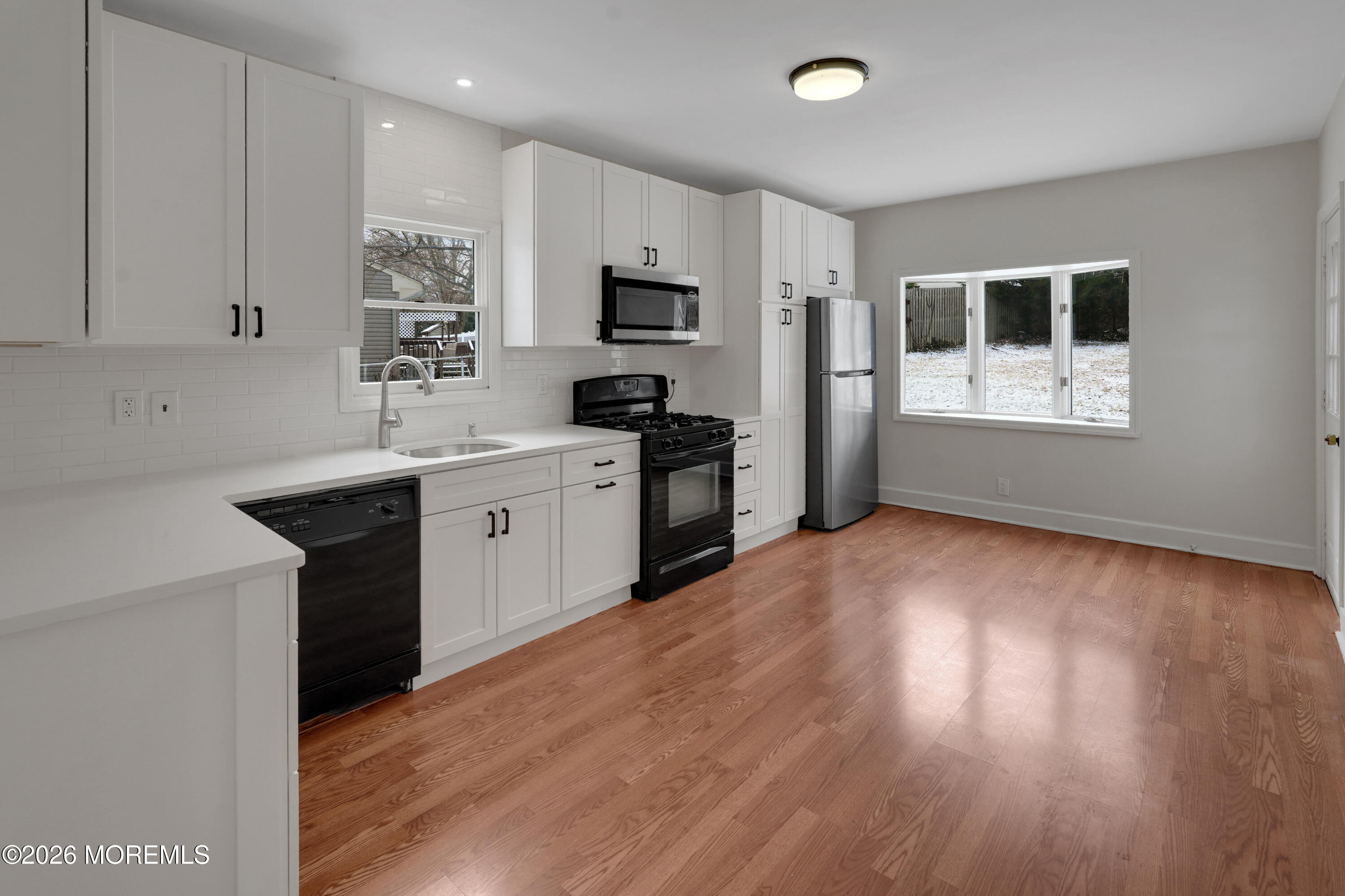 1527 Marconi Road Wall, NJ 07719 - Photo 23 of 25 a kitchen with a sink wooden floor and black appliances