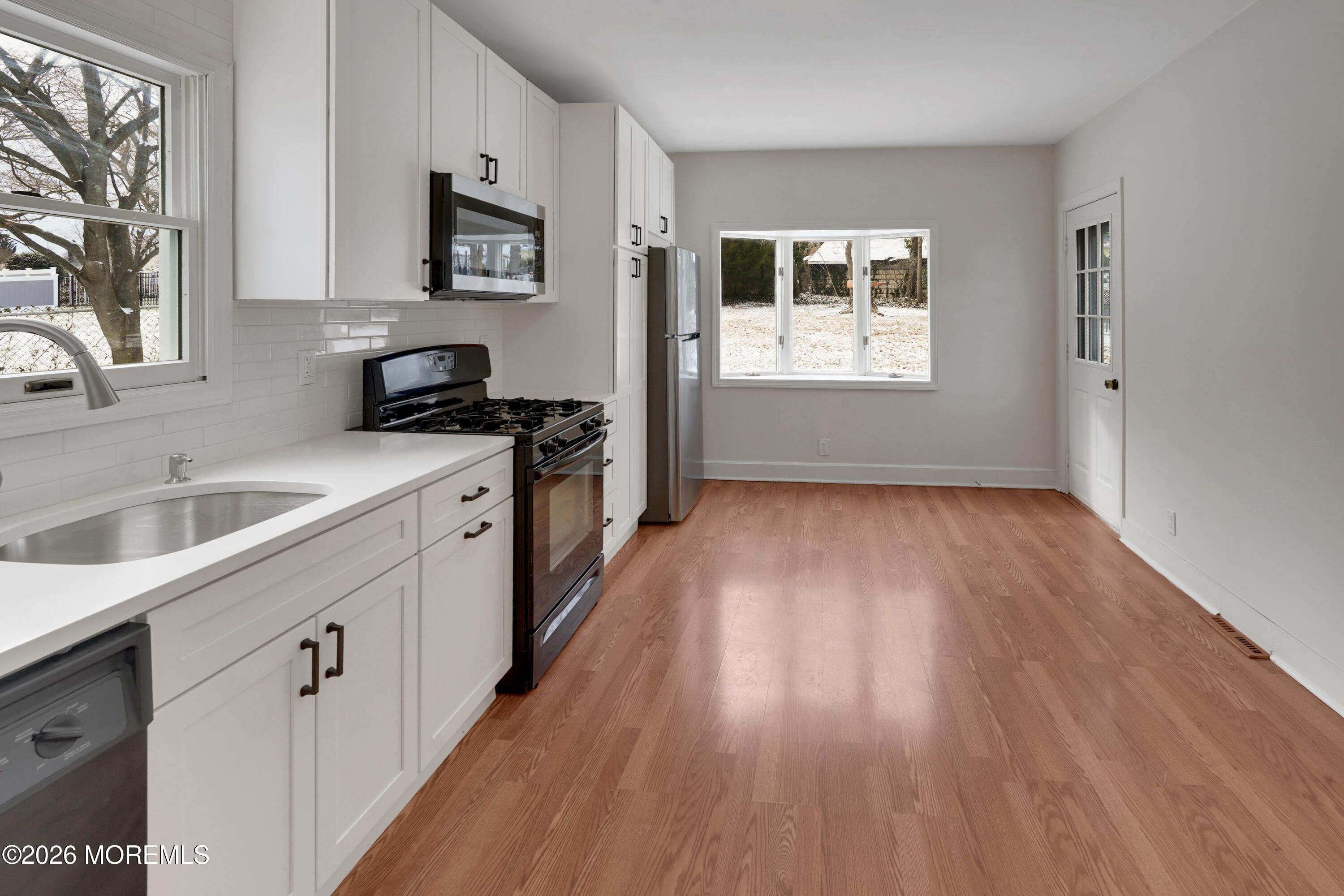 1527 Marconi Road Wall, NJ 07719 - Photo 25 of 25 a kitchen with granite countertop a sink cabinets wooden floor and stainless steel appliances