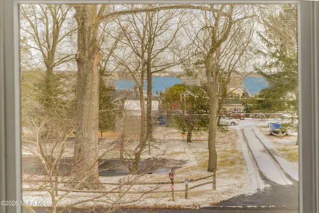 a view of a backyard with table and chairs under a large tree