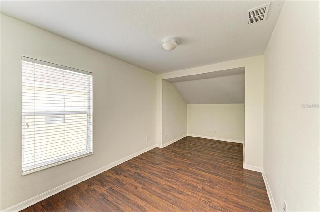 15121 Searobbin Drive Lakewood Ranch, FL 34202 - Photo 11 of 13 an empty room with wooden floor and windows
