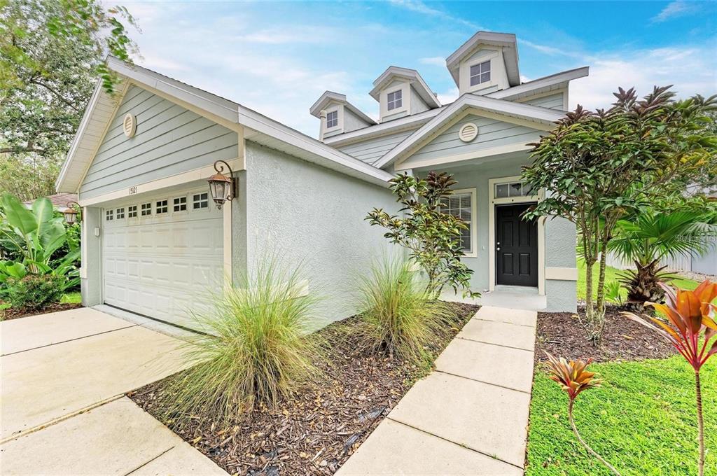 15121 Searobbin Drive Lakewood Ranch, FL 34202 - Photo 2 of 13 a view of a white house with a potted plant and a large window
