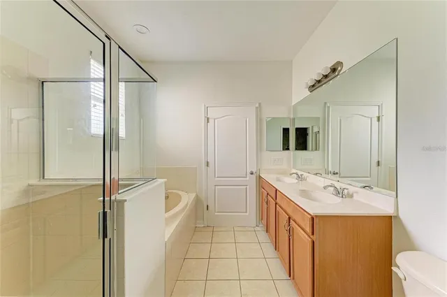 a spacious bathroom with a double vanity sink a mirror and a shower