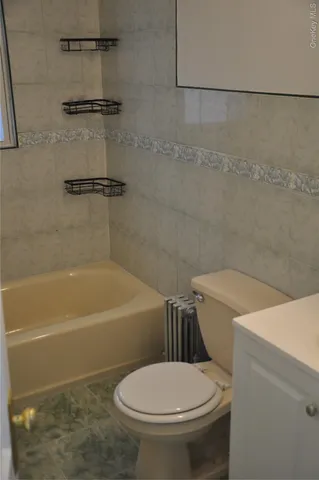 a white toilet sitting next to a bath tub