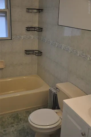 a white toilet sitting next to a bath tub