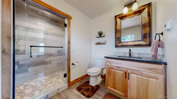 a bathroom with a granite countertop sink toilet and shower