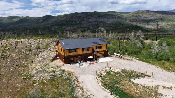 an aerial view of a house yard and mountain view in back