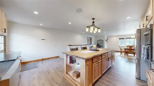 a kitchen that has a lot of cabinets stainless steel appliances and wooden floor