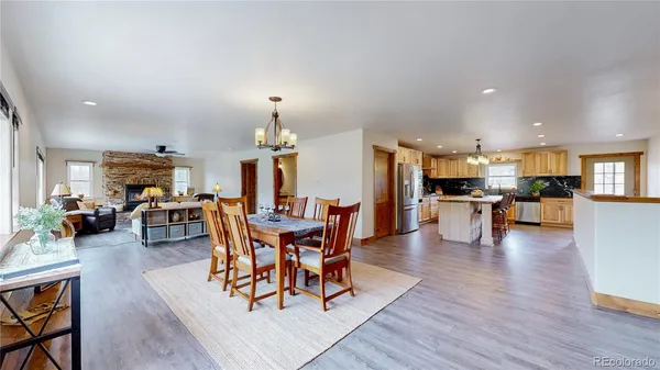 a view of a dining room and livingroom with furniture wooden floor a chandelier