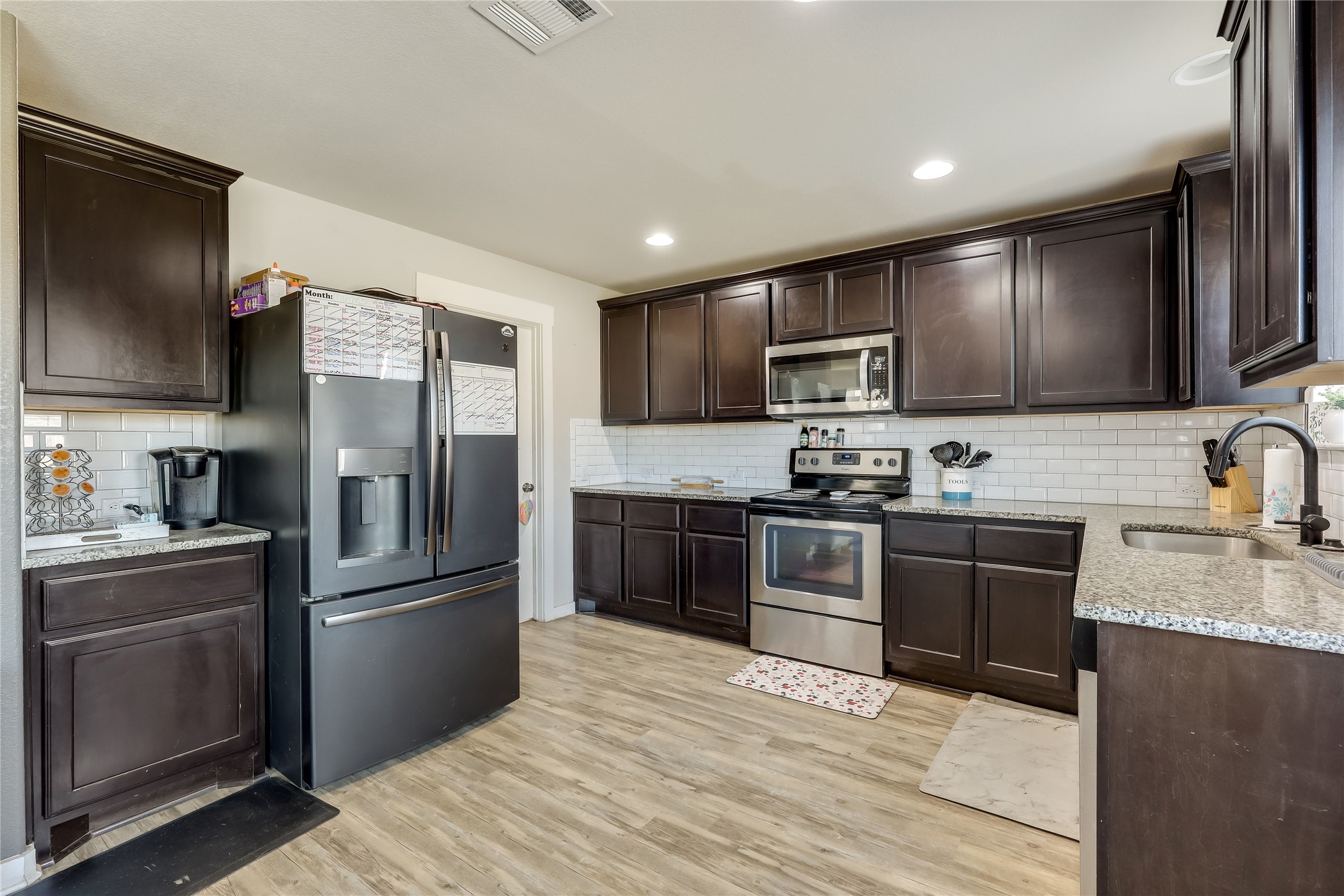 249 Trellis Boulevard Leander, TX 78641 - Photo 7 of 18 a kitchen with granite countertop stainless steel appliances and refrigerator