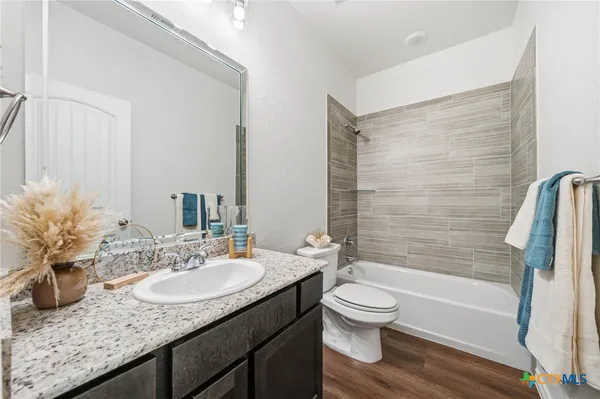 a bathroom with a granite countertop sink toilet and shower