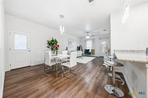 a living room with furniture a dining table and wooden floor