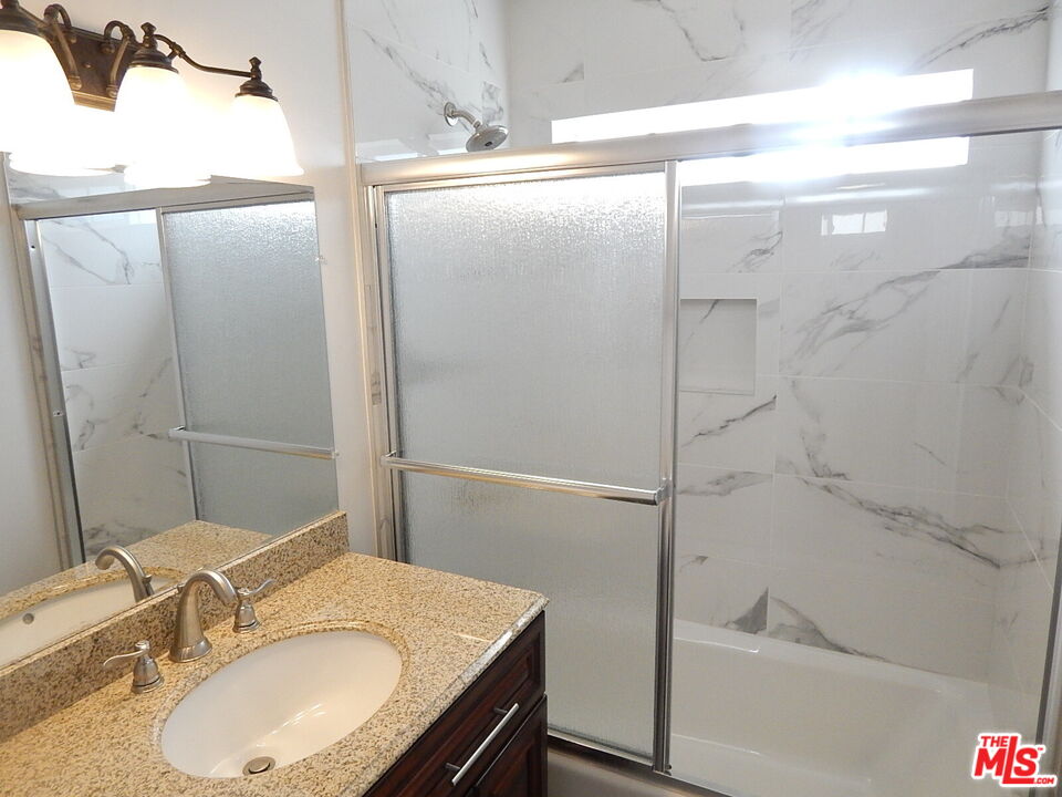2018 Hillcrest Drive Los Angeles, CA 90016 - Photo 13 of 19 a bathroom with a granite countertop shower sink vanity and mirror