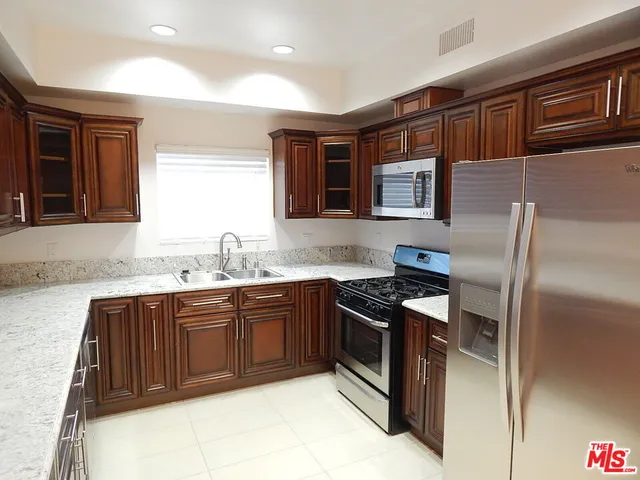 a kitchen with stainless steel appliances granite countertop a stove top oven a sink and dishwasher