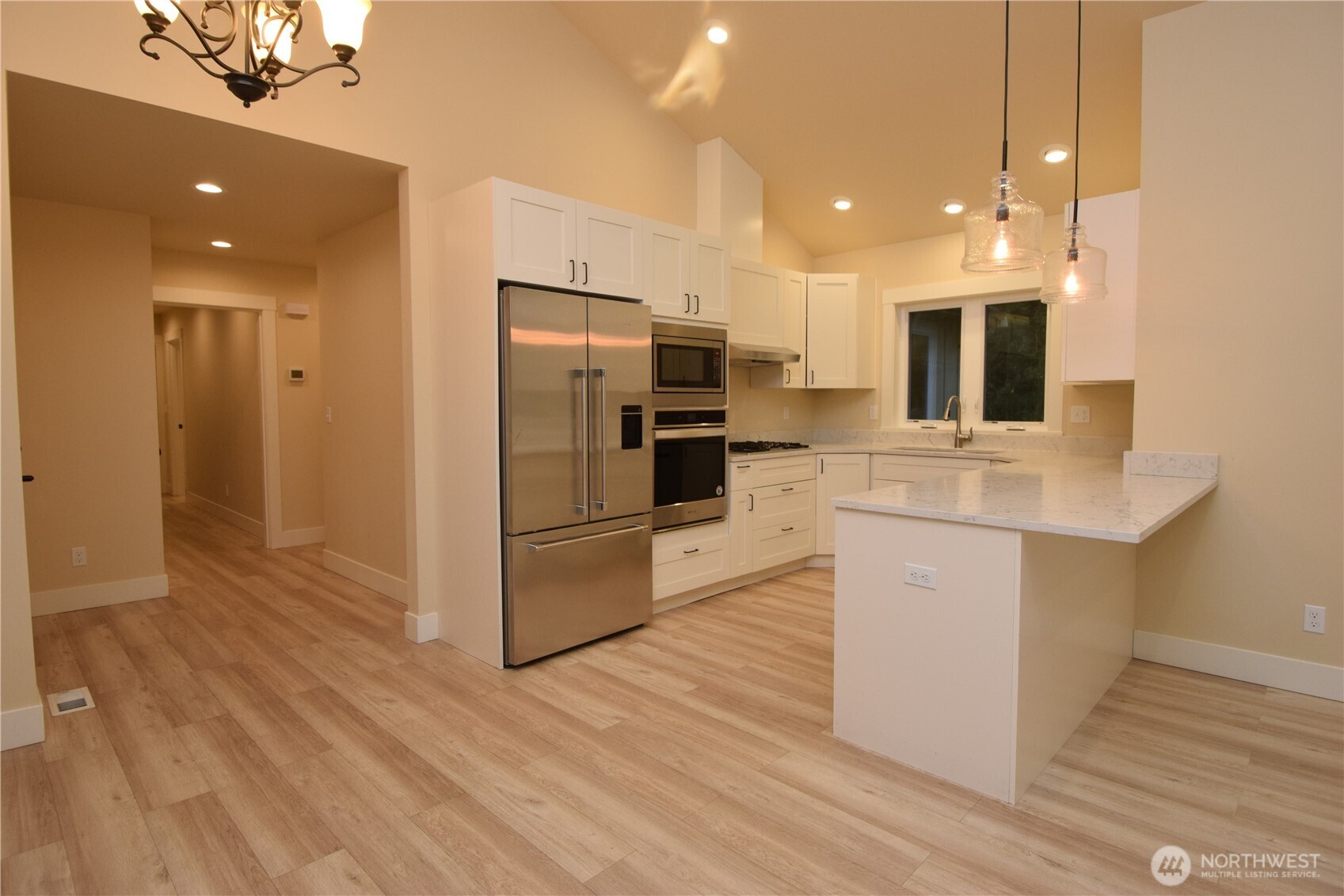 15915 Nesika Bay Road Northeast Poulsbo, WA 98370 - Photo 13 of 40 a kitchen with kitchen island a sink stainless steel appliances and cabinets