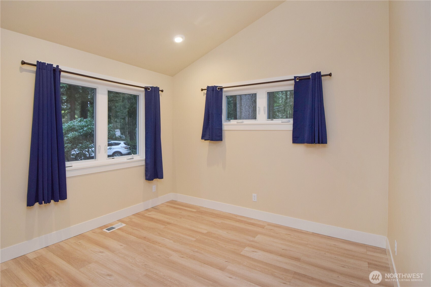 15915 Nesika Bay Road Northeast Poulsbo, WA 98370 - Photo 15 of 40 an empty room with wooden floor and windows