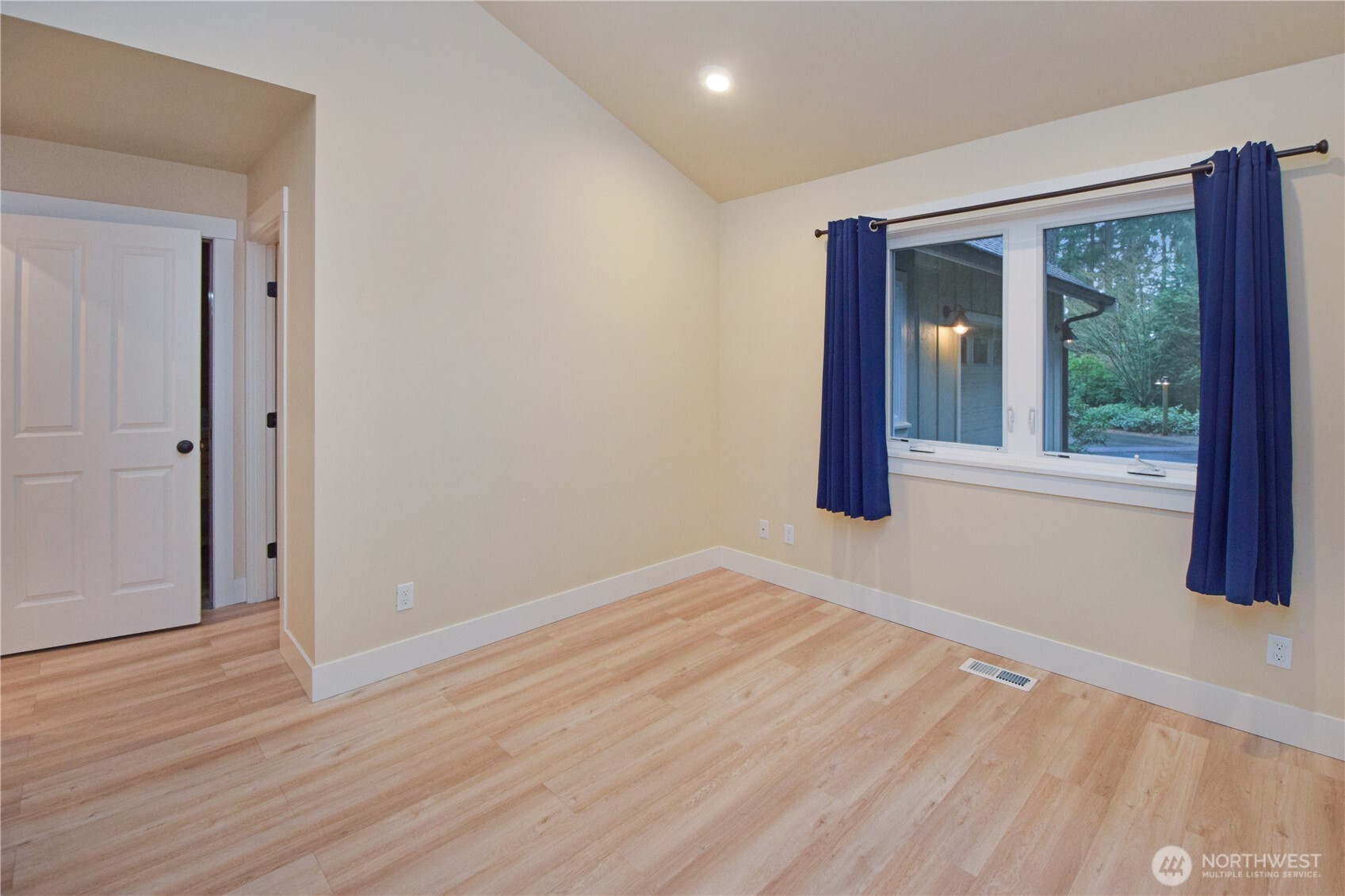 15915 Nesika Bay Road Northeast Poulsbo, WA 98370 - Photo 16 of 40 a view of an empty room with wooden floor and a window