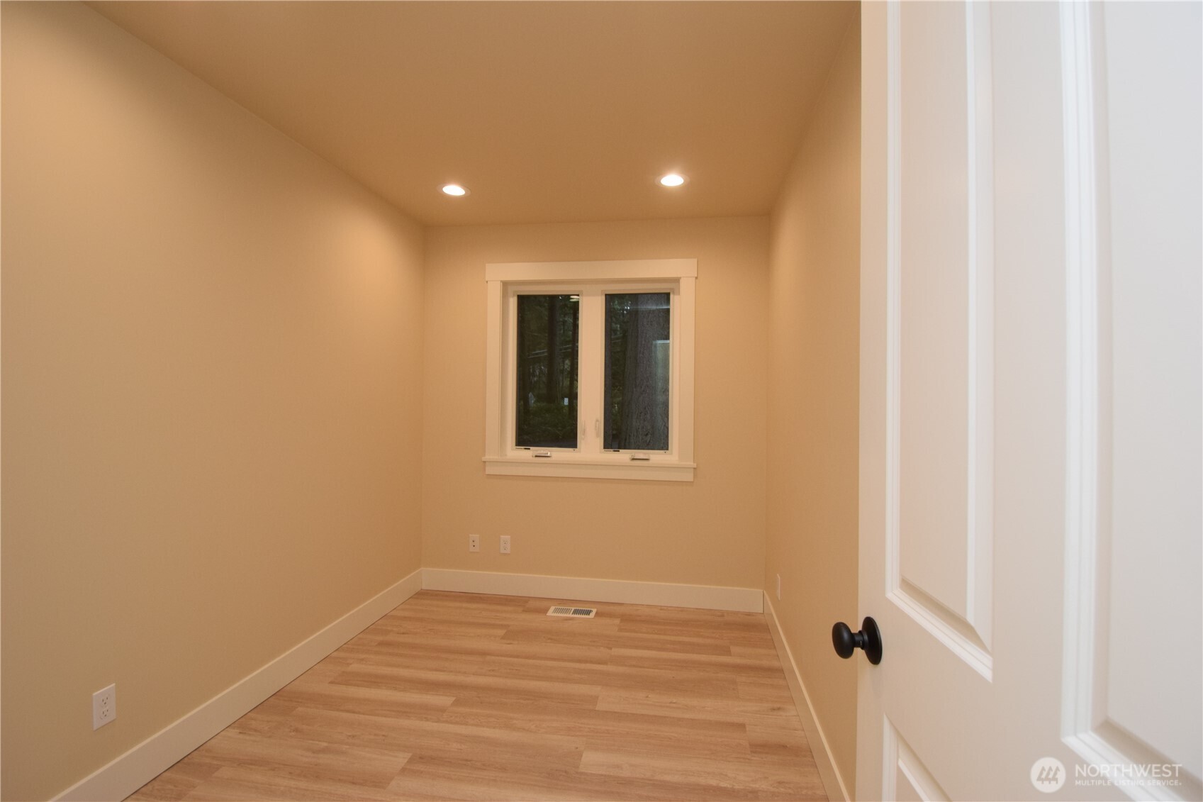 15915 Nesika Bay Road Northeast Poulsbo, WA 98370 - Photo 21 of 40 a view of empty room with wooden floor and fan
