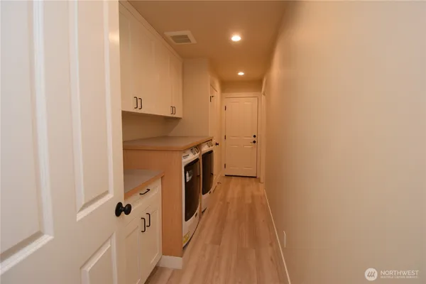 a view of a hallway with wooden floor and staircase