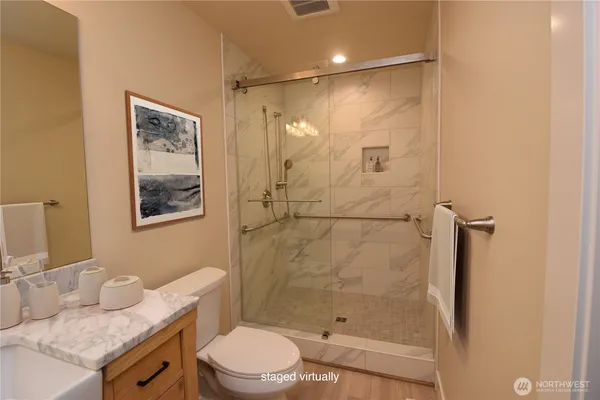 a bathroom with a granite countertop sink toilet and shower