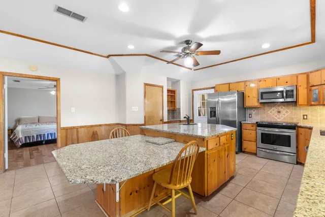 a kitchen with stainless steel appliances granite countertop a sink dishwasher stove and refrigerator with wooden floor