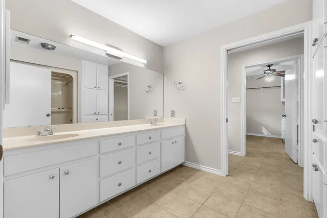 a spacious bathroom with double sink and a mirror
