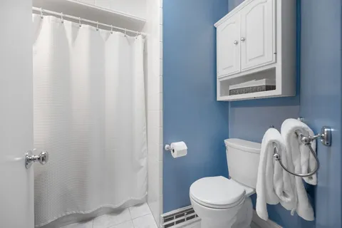 a bathroom with a toilet and a mirror