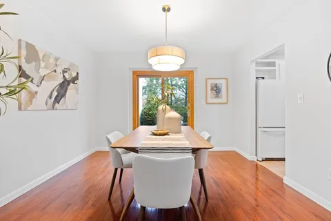 a dining room with furniture a chandelier and wooden floor