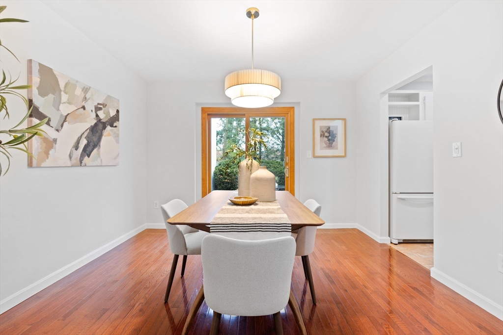 1 Charles Street, Unit N Reading, MA 01867 - Photo 5 of 17 a dining room with furniture a chandelier and wooden floor