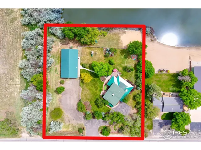 an aerial view of ocean and residential houses with outdoor space