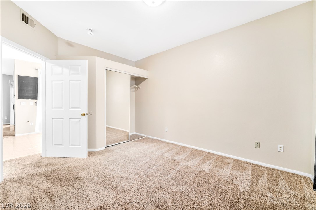 2050 West Warm Springs Road, Unit 2411 Henderson, NV 89014 - Photo 24 of 37 A well-lit bedroom with soft carpet offers a blank canvas for personalization.