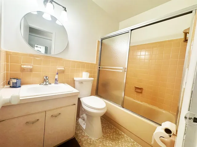 a bathroom with a sink a toilet and a mirror