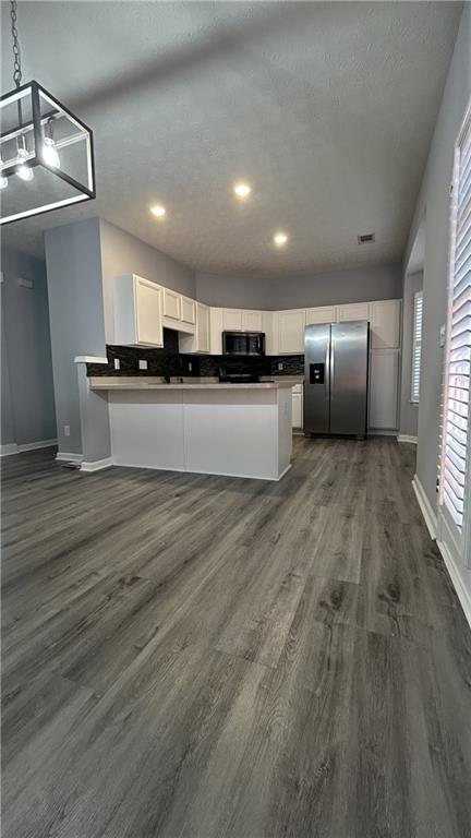 4711 Poplar Ridge Court Oakwood, GA 30566 - Photo 15 of 15 a large white kitchen with wooden floors and stainless steel appliances