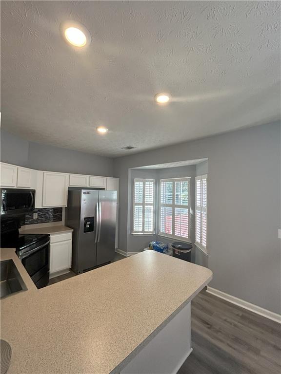 4711 Poplar Ridge Court Oakwood, GA 30566 - Photo 5 of 15 a large kitchen with a refrigerator a sink dishwasher a stove and a refrigerator with wooden floor