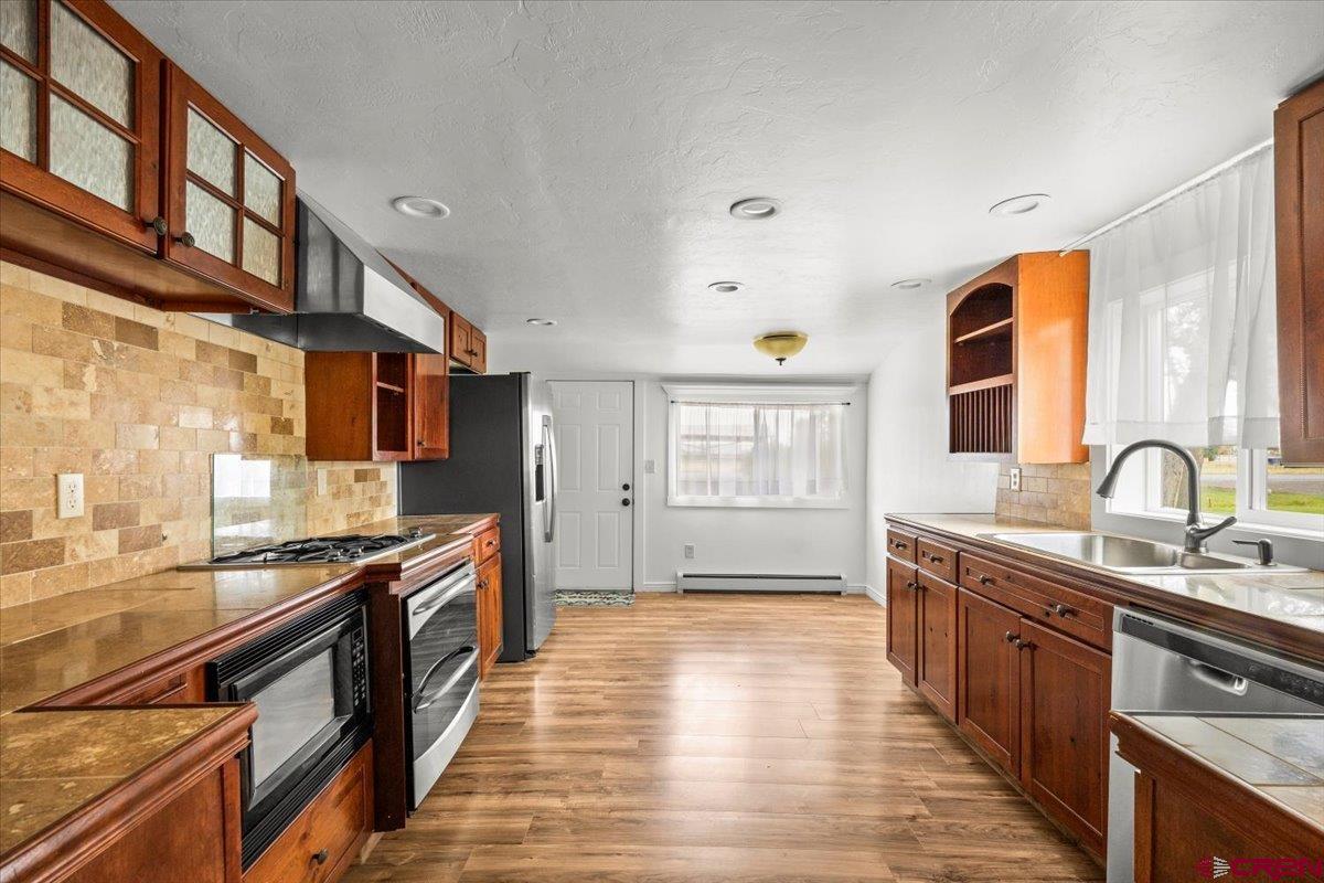 2410 6450th Road Montrose, CO 81401 - Photo 1 of 23 a large kitchen with stainless steel appliances granite countertop a stove and a sink