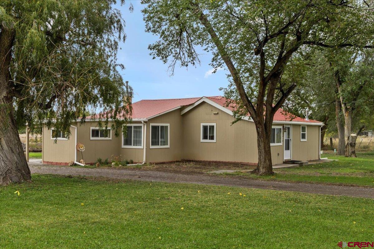 2410 6450th Road Montrose, CO 81401 - Photo 11 of 23 a front view of house with yard and trees