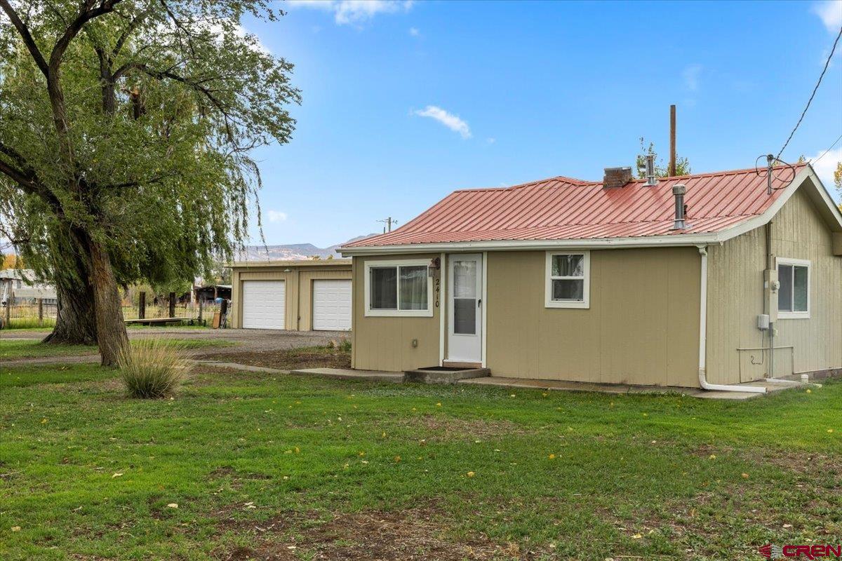 2410 6450th Road Montrose, CO 81401 - Photo 13 of 23 a front view of a house with a garden