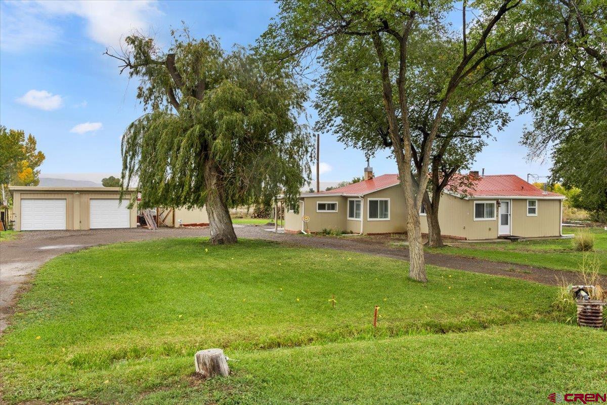 2410 6450th Road Montrose, CO 81401 - Photo 14 of 23 a front view of a house with garden