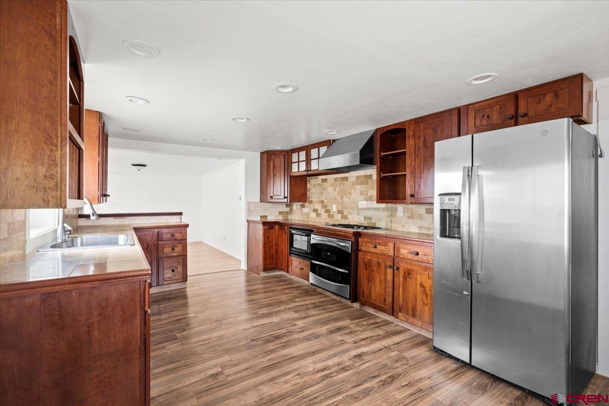 2410 6450th Road Montrose, CO 81401 - Photo 19 of 23 a kitchen with stainless steel appliances granite countertop a refrigerator a sink and a stove