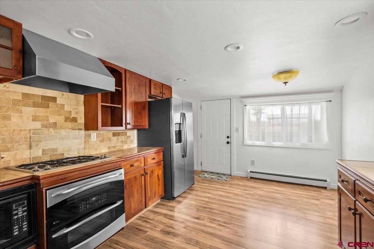 2410 6450th Road Montrose, CO 81401 - Photo 20 of 23 a kitchen with stainless steel appliances a stove cabinets and wooden floor