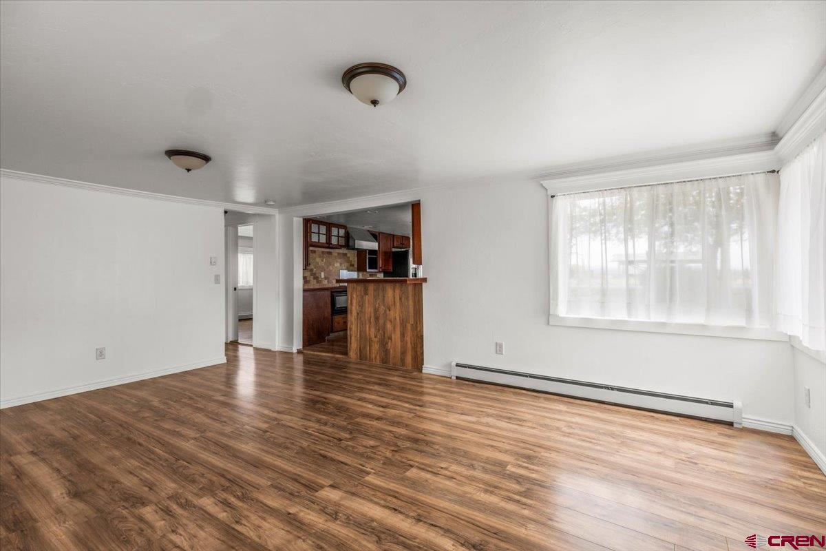 2410 6450th Road Montrose, CO 81401 - Photo 22 of 23 an empty room with wooden floor and windows