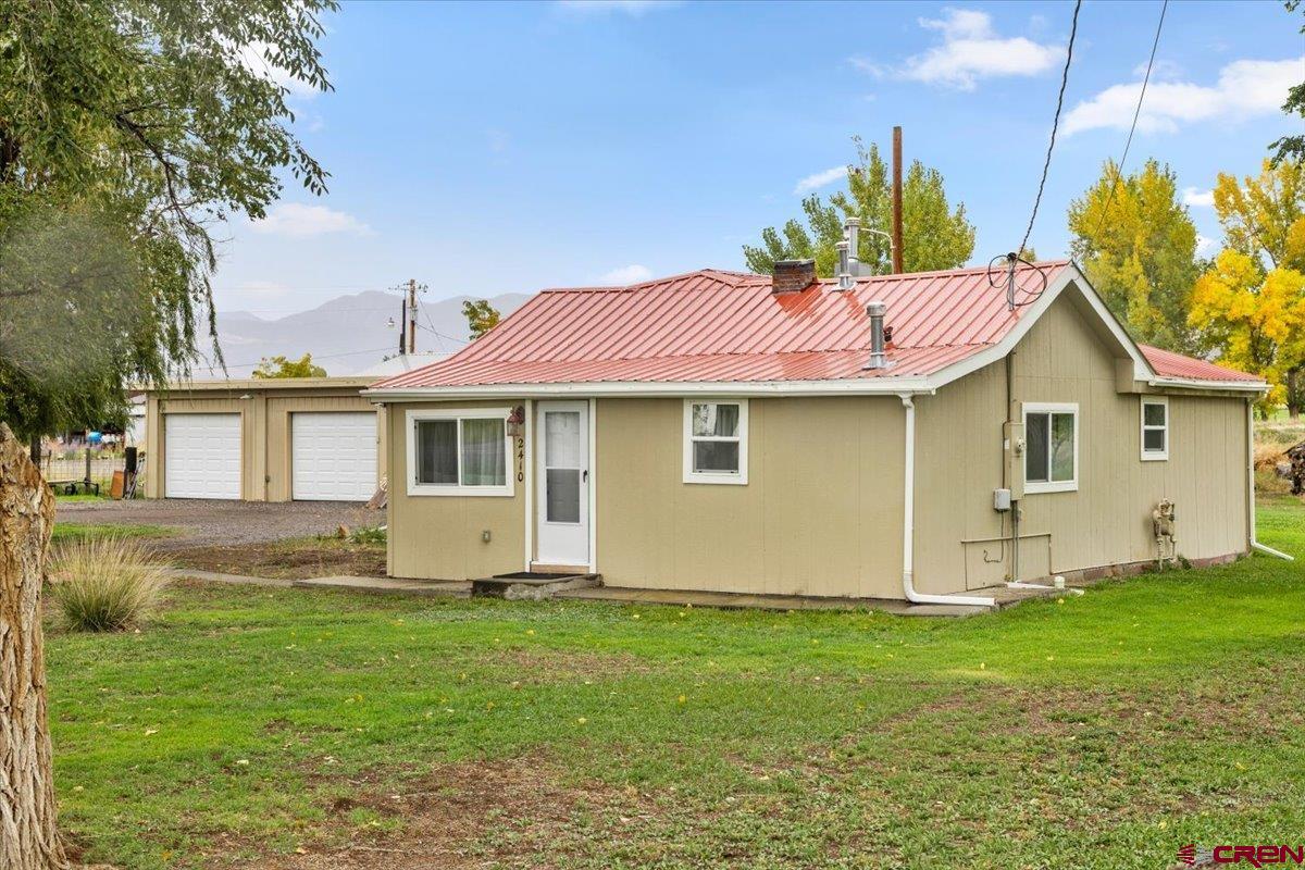 2410 6450th Road Montrose, CO 81401 - Photo 23 of 23 a front view of a house with a garden and yard