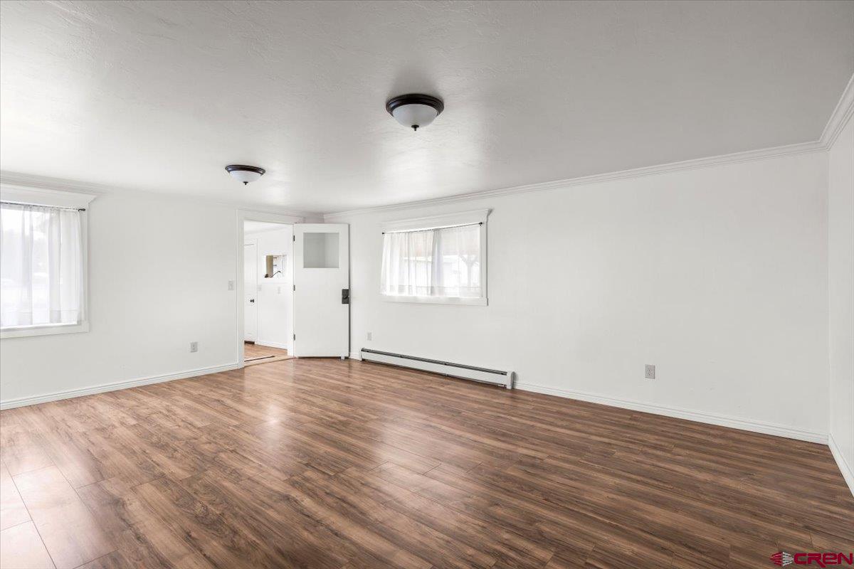 2410 6450th Road Montrose, CO 81401 - Photo 4 of 23 an empty room with wooden floor and windows