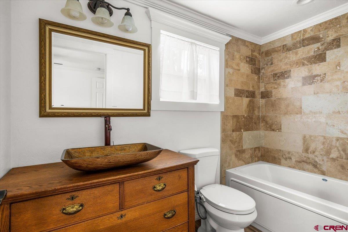 2410 6450th Road Montrose, CO 81401 - Photo 5 of 23 a bathroom with a sink a toilet and bathtub
