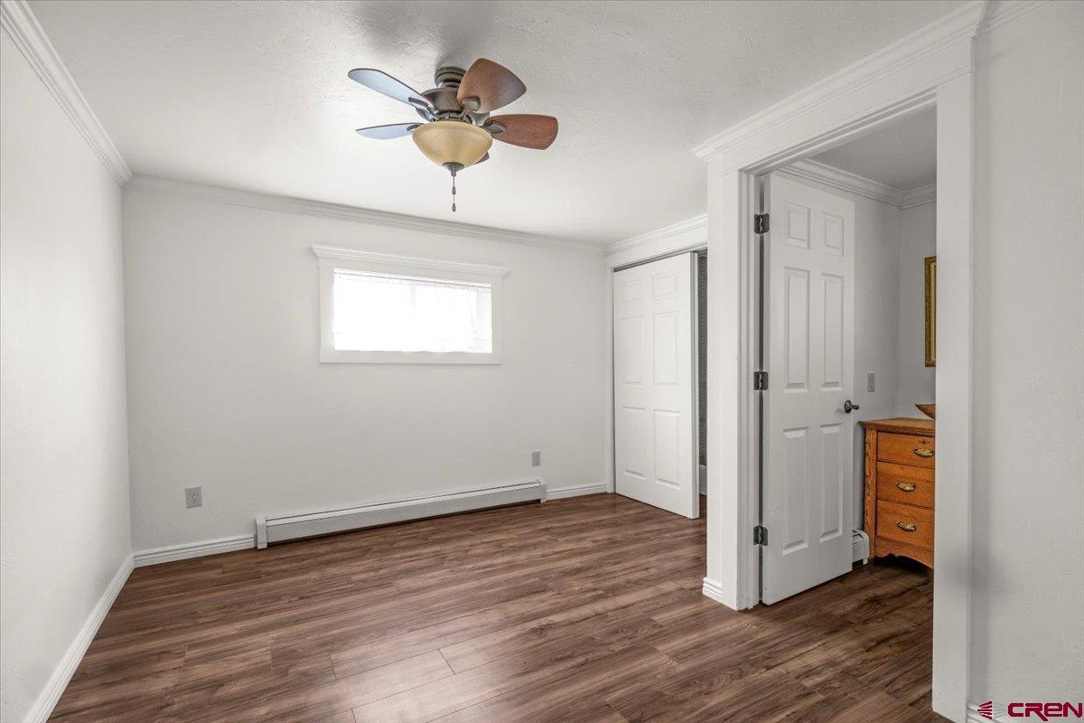 2410 6450th Road Montrose, CO 81401 - Photo 6 of 23 an empty room with wooden floor and a ceiling fan