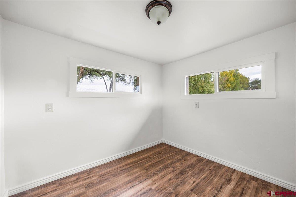2410 6450th Road Montrose, CO 81401 - Photo 8 of 23 an empty room with wooden floor and windows