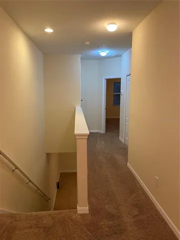 a view of an empty room with a chandelier fan