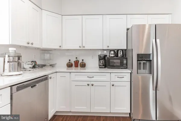 a kitchen with stainless steel appliances white cabinets and a refrigerator